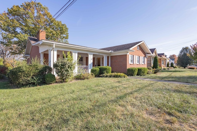 ranch-style house featuring covered porch and a front yard