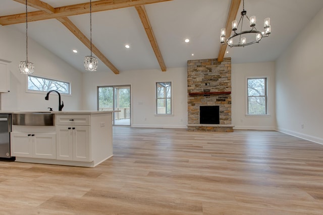 kitchen with high vaulted ceiling, a wealth of natural light, pendant lighting, and white cabinets