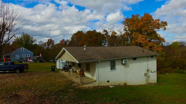 view of property exterior with a wall mounted air conditioner and a yard