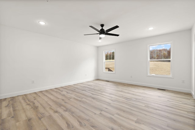 empty room featuring recessed lighting, visible vents, a ceiling fan, light wood-type flooring, and baseboards