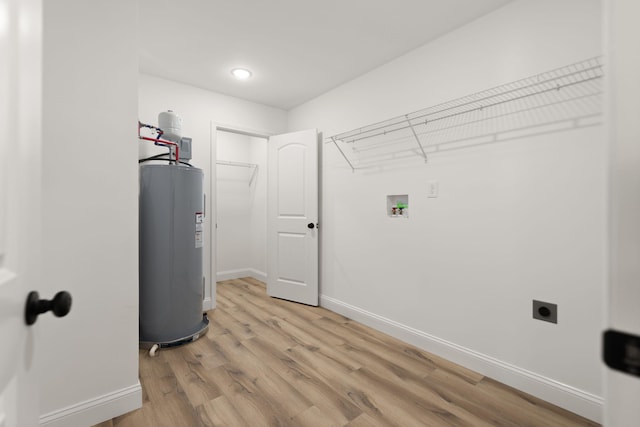 clothes washing area featuring laundry area, light wood finished floors, electric water heater, hookup for an electric dryer, and washer hookup