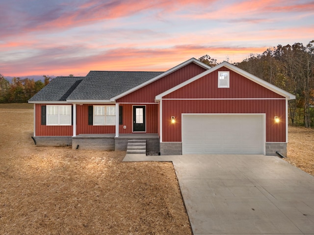 view of front of house featuring driveway, a shingled roof, and an attached garage