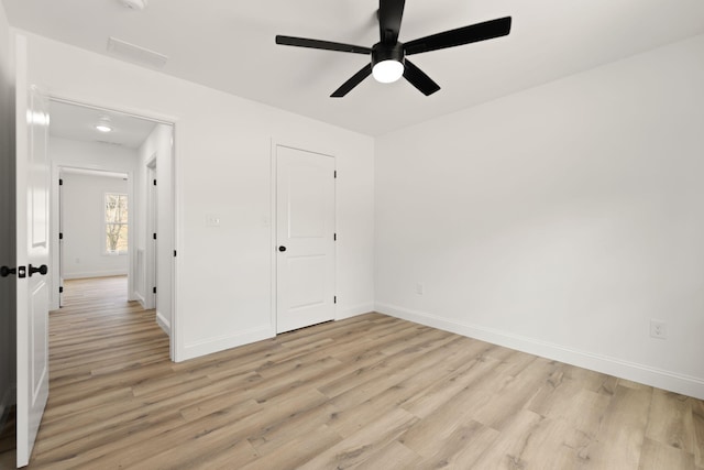 unfurnished bedroom with light wood-type flooring, ceiling fan, and baseboards