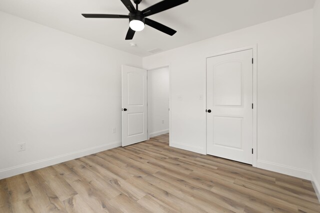 unfurnished bedroom featuring light wood-style floors, ceiling fan, and baseboards