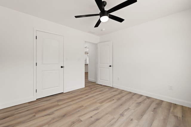 unfurnished bedroom with light wood-type flooring, ceiling fan, and baseboards