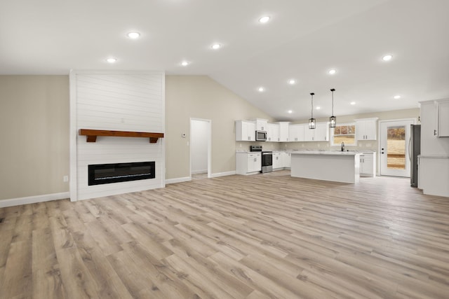 unfurnished living room featuring vaulted ceiling, light wood-type flooring, a fireplace, and baseboards