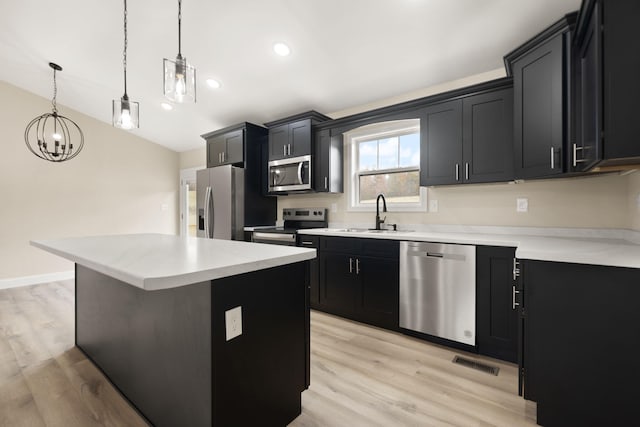 kitchen with appliances with stainless steel finishes, visible vents, a sink, and dark cabinets