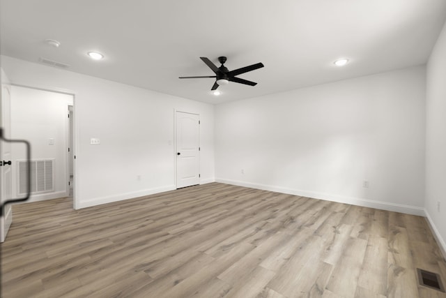 empty room featuring light wood-type flooring, visible vents, and a ceiling fan