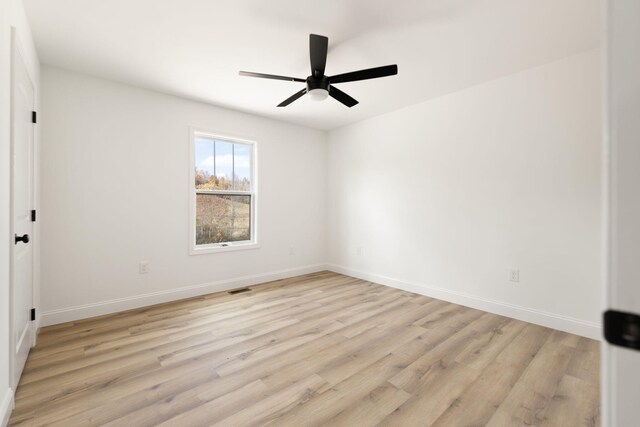 empty room featuring ceiling fan, light wood-type flooring, visible vents, and baseboards