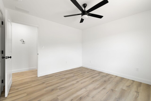 unfurnished room featuring ceiling fan, light wood-style flooring, and baseboards