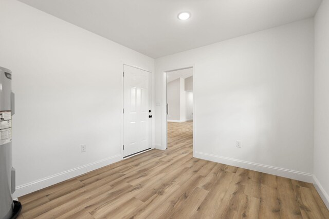 empty room with light wood-type flooring and baseboards