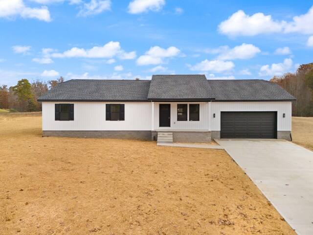 view of front of house featuring a shingled roof, concrete driveway, and an attached garage