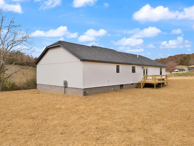 view of side of property featuring crawl space, roof with shingles, and a wooden deck