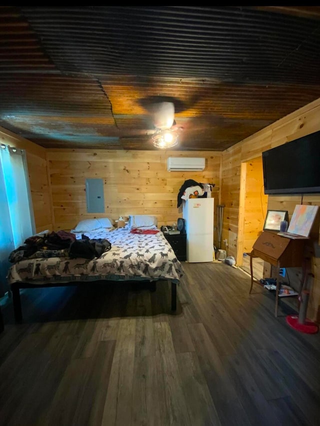 bedroom with wood walls, an AC wall unit, hardwood / wood-style flooring, electric panel, and white refrigerator