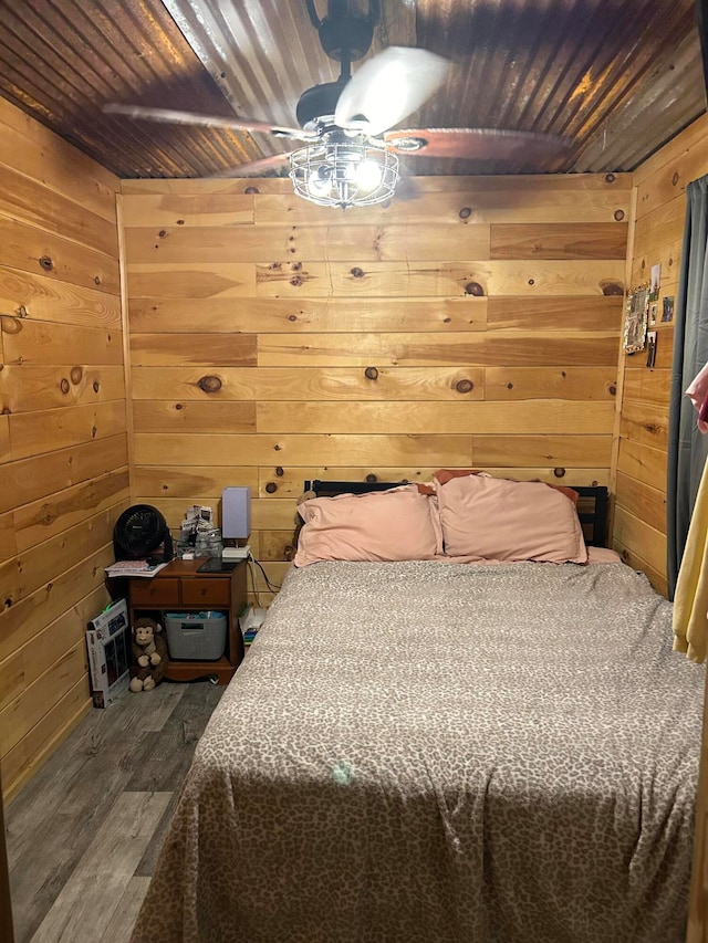 bedroom featuring wood walls and dark hardwood / wood-style flooring