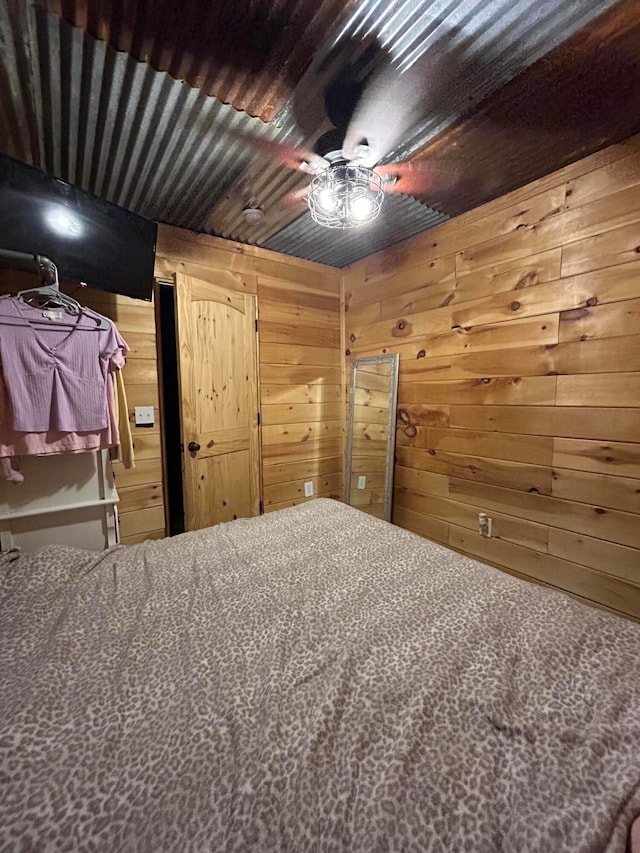 unfurnished bedroom with ceiling fan and wood walls