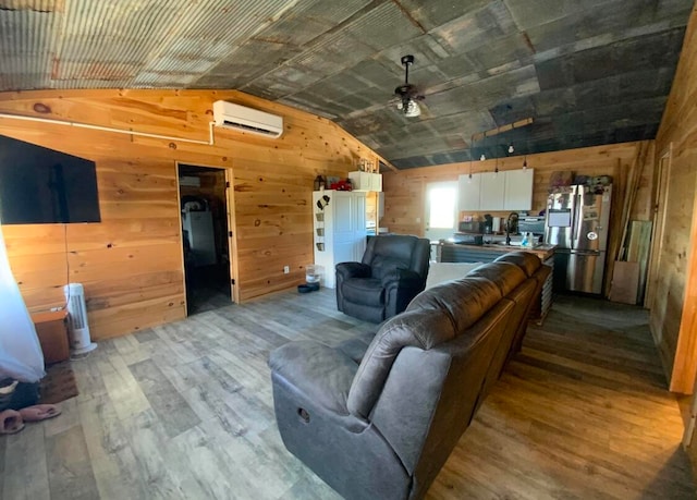 living room featuring lofted ceiling, wooden walls, light hardwood / wood-style flooring, and ceiling fan