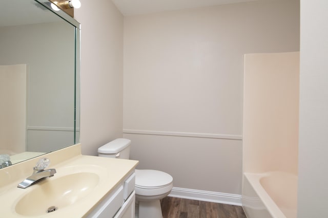 bathroom with toilet, vanity, and hardwood / wood-style flooring