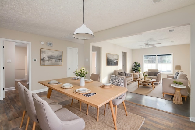 dining space with a textured ceiling, dark hardwood / wood-style floors, and ceiling fan