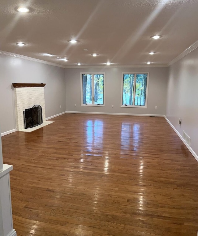 unfurnished living room with crown molding, dark wood-type flooring, and a brick fireplace