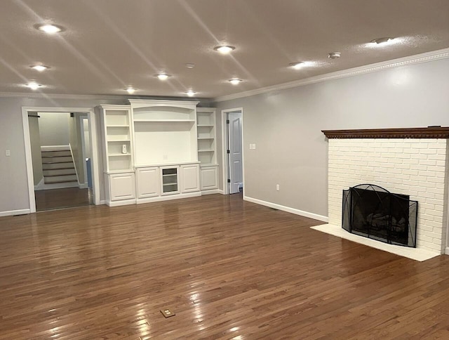 unfurnished living room with a fireplace, ornamental molding, and dark wood-type flooring