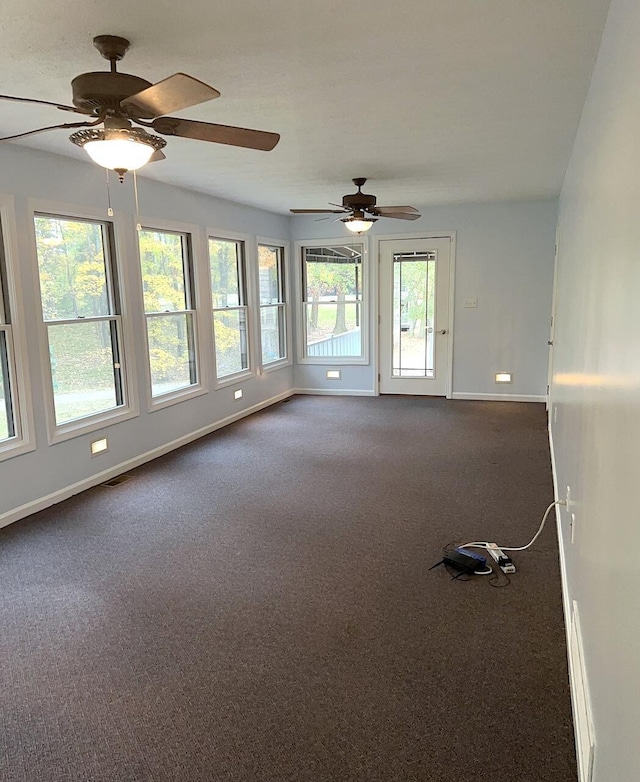 spare room with dark carpet and ceiling fan