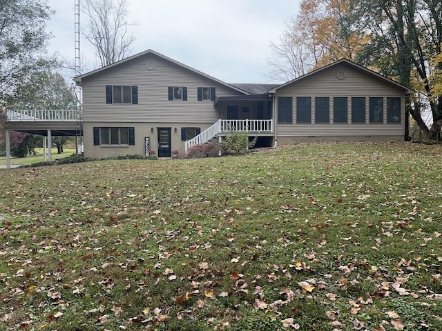 rear view of property featuring a lawn