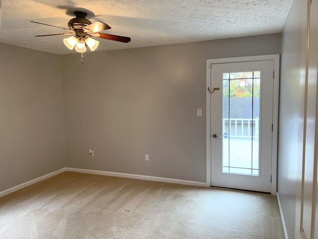 doorway with ceiling fan, light colored carpet, and a textured ceiling