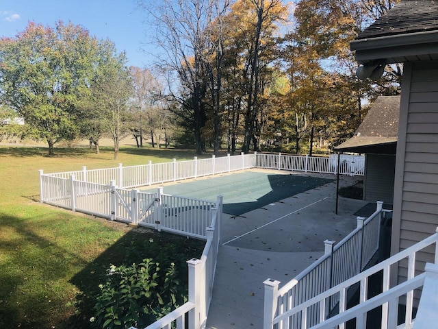 view of tennis court featuring a yard