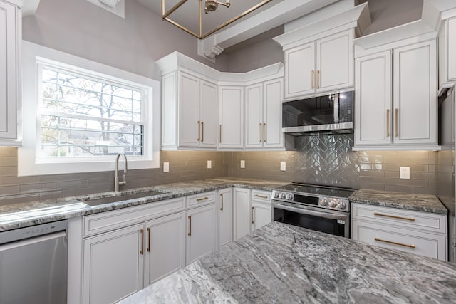 kitchen with stainless steel appliances, sink, light stone countertops, white cabinets, and tasteful backsplash