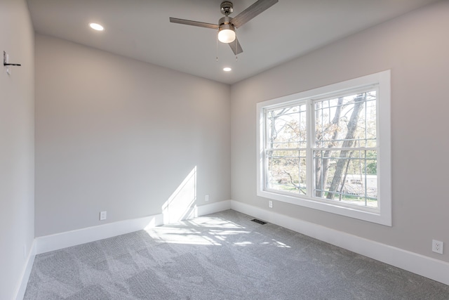 carpeted spare room with ceiling fan