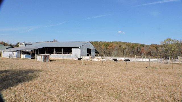 back of house featuring an outbuilding and a rural view