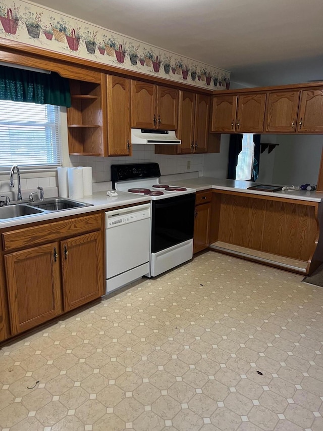 kitchen with tasteful backsplash, sink, and white appliances