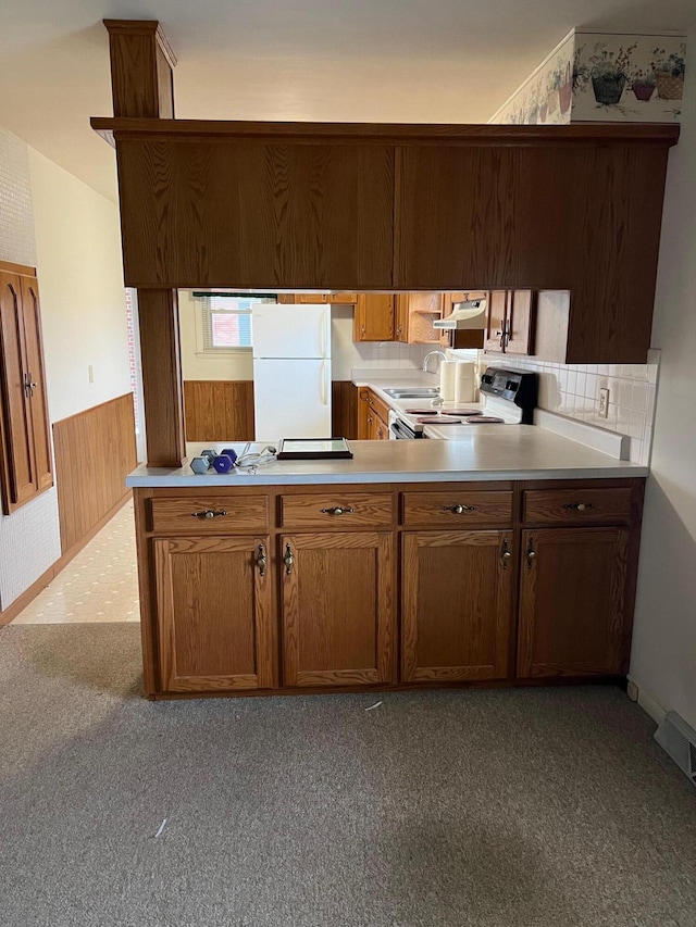 kitchen featuring carpet flooring, electric range, tasteful backsplash, white fridge, and extractor fan