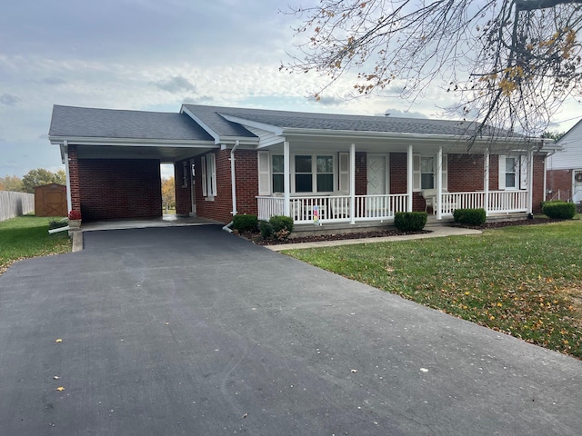 single story home featuring a porch, a carport, and a front lawn