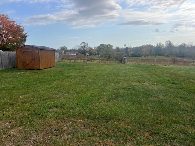 view of yard featuring a rural view and a shed