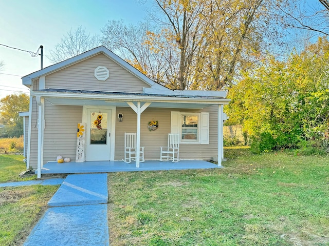 bungalow with covered porch and a front yard