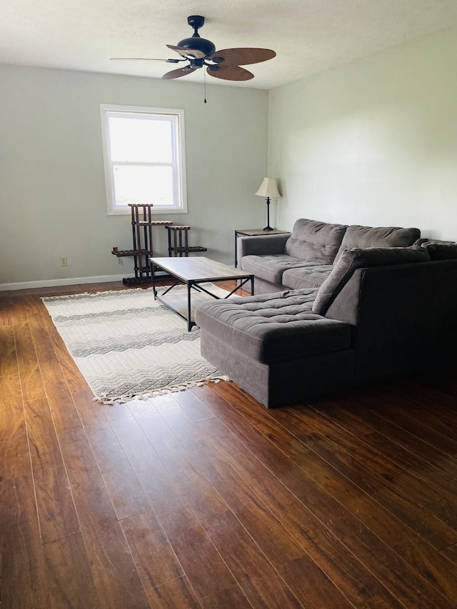 living room with ceiling fan and dark hardwood / wood-style flooring