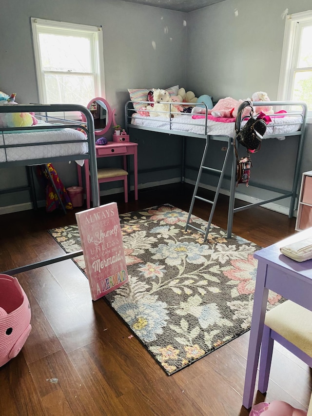 bedroom with dark hardwood / wood-style flooring and multiple windows