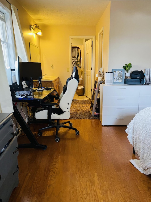 home office with hardwood / wood-style floors and a textured ceiling