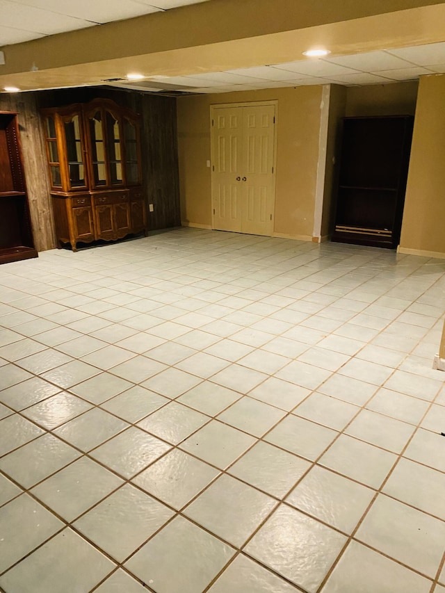 unfurnished room featuring light tile patterned floors and a paneled ceiling