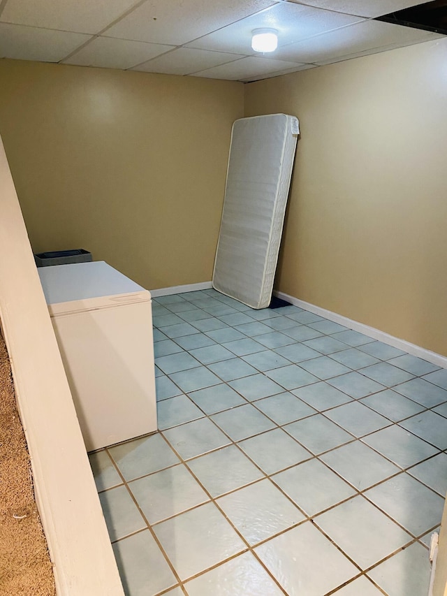 tiled empty room with a paneled ceiling