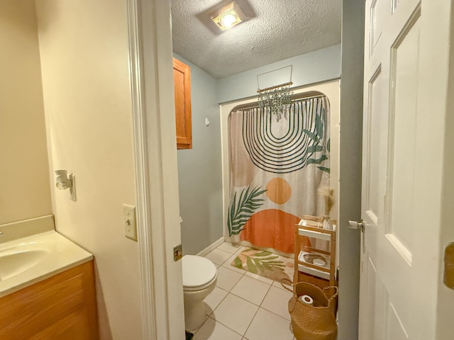 bathroom featuring vanity, tile patterned floors, a shower with shower curtain, toilet, and a textured ceiling