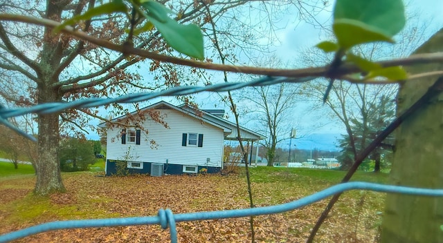 view of home's exterior featuring central AC unit and a lawn