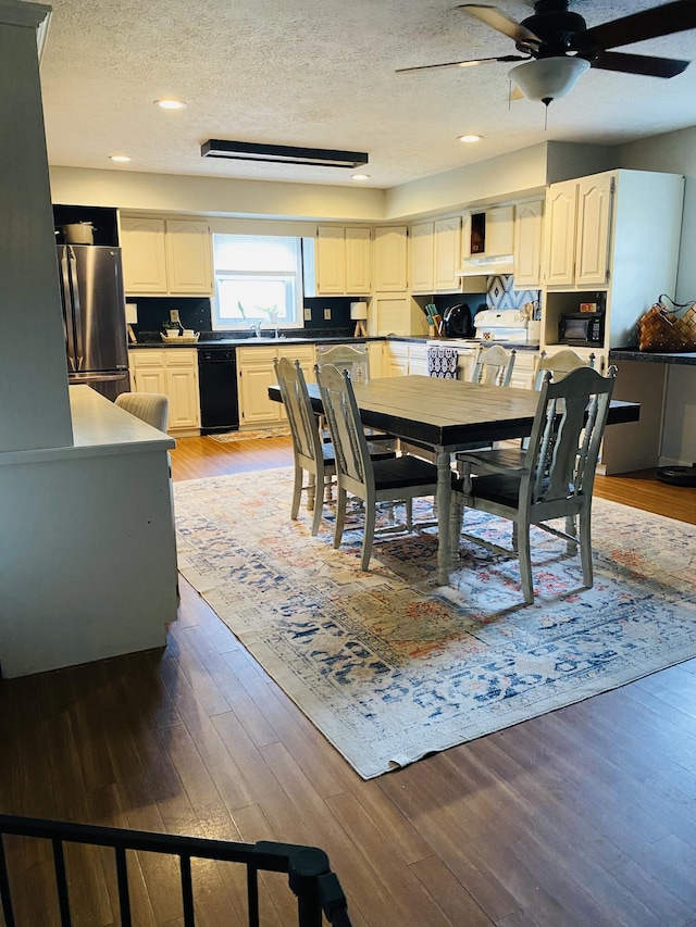 dining space with hardwood / wood-style floors, a textured ceiling, and sink