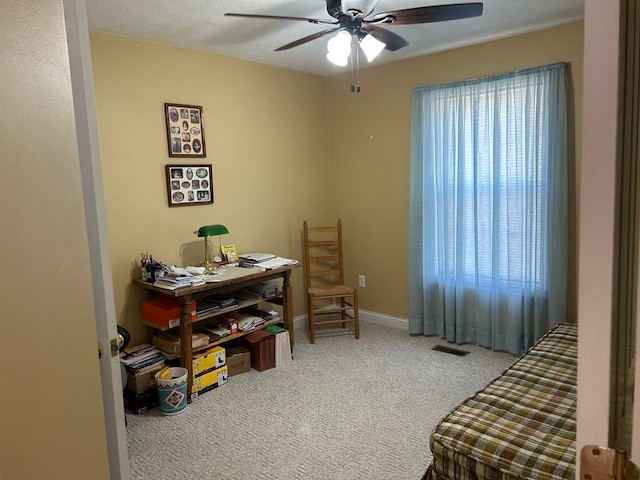 carpeted office featuring ceiling fan