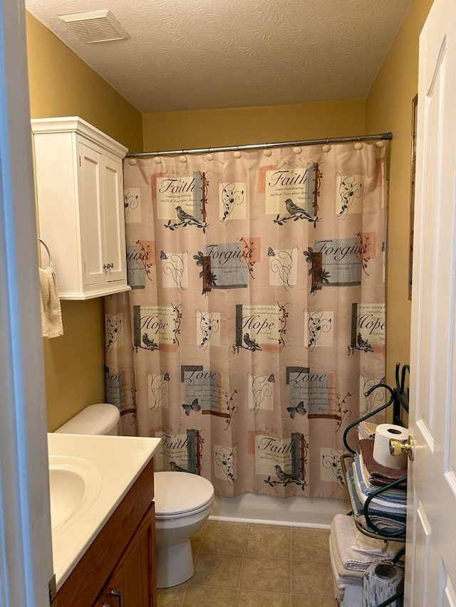 full bathroom with shower / tub combo, a textured ceiling, toilet, vanity, and tile patterned flooring