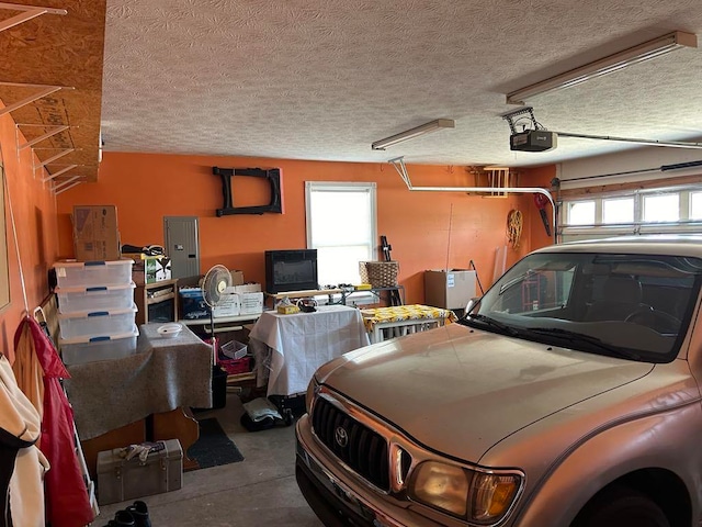 garage with a garage door opener and electric panel