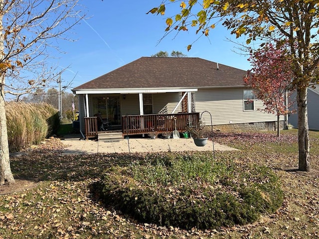 rear view of house featuring a wooden deck