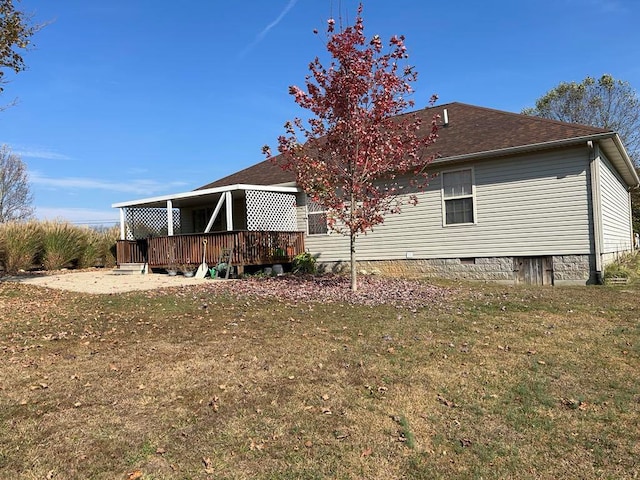 rear view of house with a yard and a wooden deck